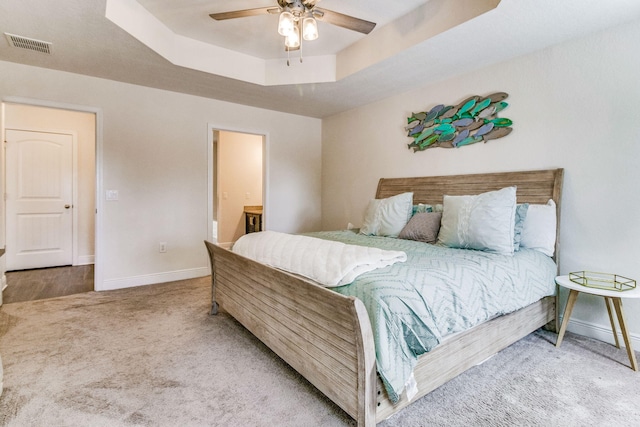 bedroom with ceiling fan, a raised ceiling, and carpet