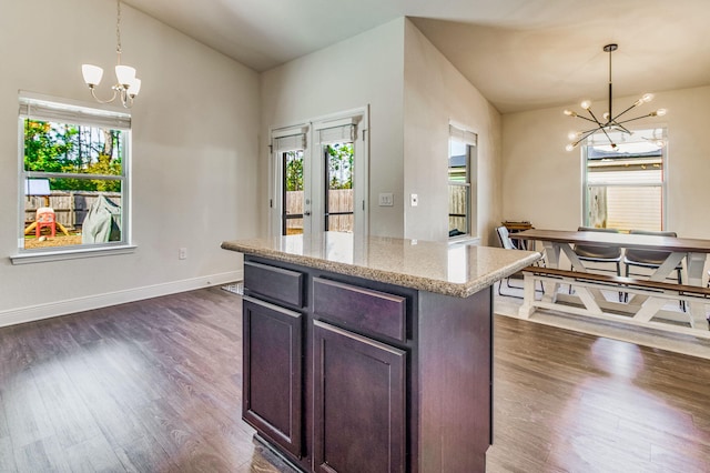 kitchen featuring hanging light fixtures, light stone counters, and an inviting chandelier