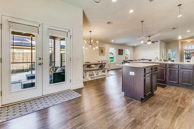 kitchen with french doors, a center island, dark brown cabinets, dark hardwood / wood-style floors, and pendant lighting