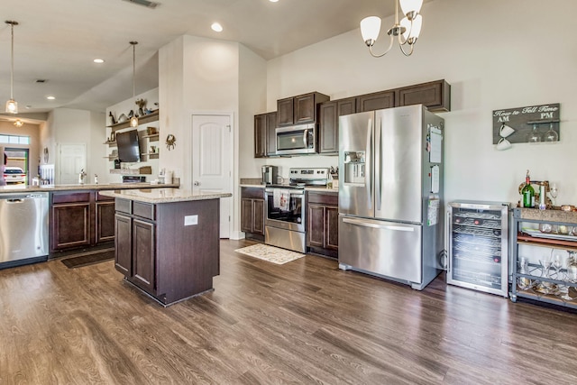 kitchen featuring pendant lighting, beverage cooler, dark hardwood / wood-style flooring, a center island, and stainless steel appliances