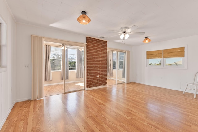 empty room featuring ceiling fan, light wood-style flooring, and baseboards