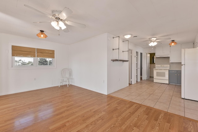 interior space featuring light wood finished floors, ceiling fan, white appliances, and white cabinets