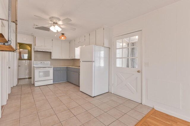 kitchen with white appliances, under cabinet range hood, white cabinets, and a ceiling fan