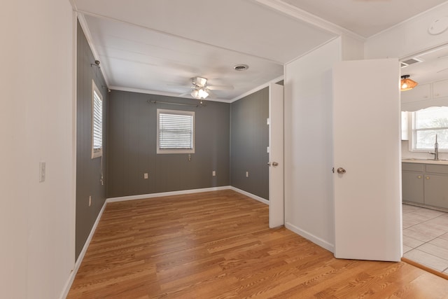 unfurnished room with ornamental molding, a wealth of natural light, and light wood finished floors