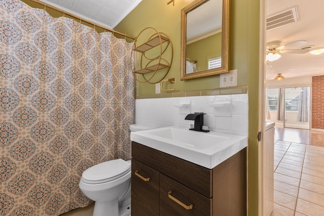 full bath featuring visible vents, toilet, crown molding, vanity, and tile walls