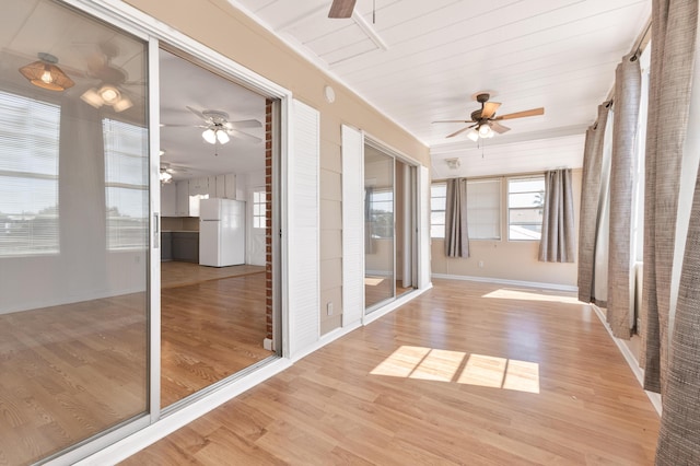 unfurnished sunroom with ceiling fan