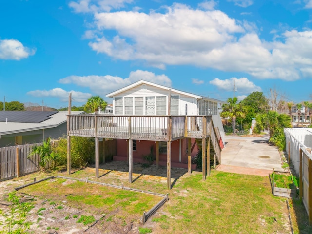 rear view of house featuring a deck, a yard, a patio, and a fenced backyard