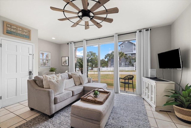 tiled living room featuring ceiling fan and a wall of windows