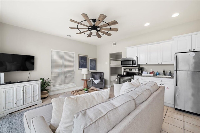 tiled living room featuring sink and ceiling fan