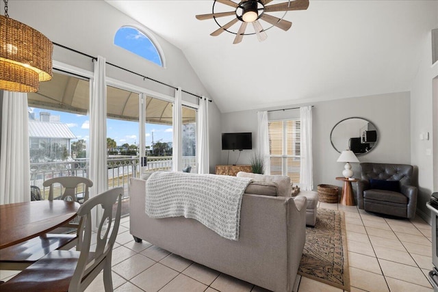 tiled living room with ceiling fan, vaulted ceiling, and a wealth of natural light