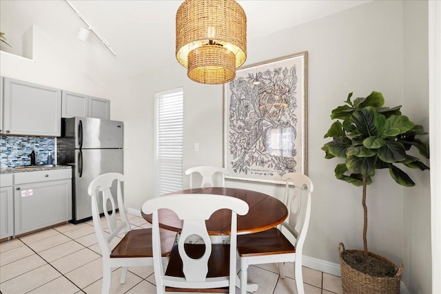 dining area featuring an inviting chandelier, sink, track lighting, and light tile patterned flooring