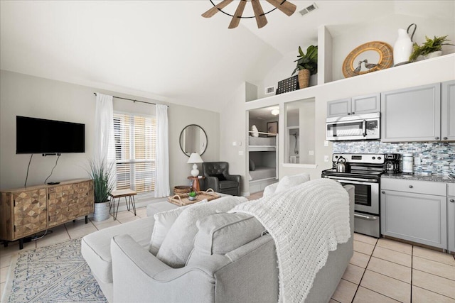 tiled living room with ceiling fan and lofted ceiling