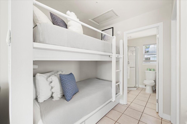 tiled bedroom featuring ensuite bathroom