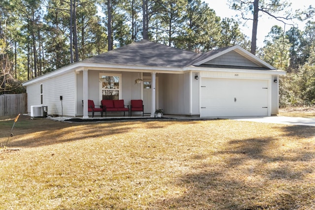 ranch-style house featuring cooling unit, a garage, covered porch, and a front yard