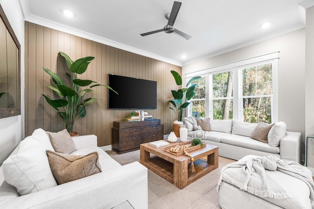 living room with crown molding, ceiling fan, and wood walls