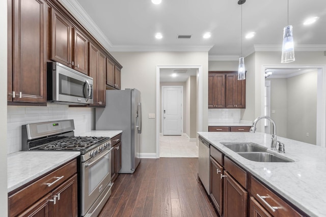 kitchen featuring sink, hanging light fixtures, ornamental molding, dark brown cabinetry, and stainless steel appliances