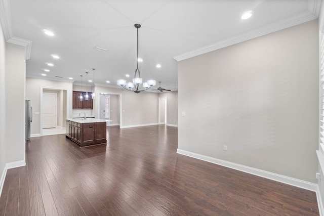 interior space featuring crown molding, sink, a notable chandelier, and dark wood-type flooring