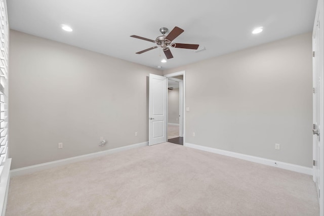 spare room with light colored carpet and ceiling fan