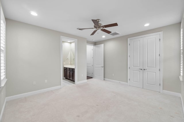 unfurnished bedroom with ceiling fan, connected bathroom, and light colored carpet