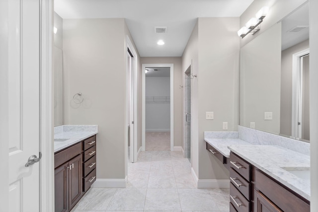 bathroom featuring vanity, tile patterned floors, and a shower with door