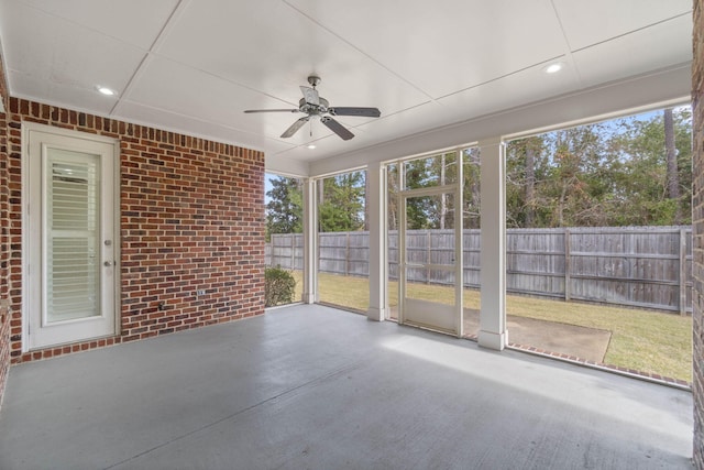 unfurnished sunroom with ceiling fan