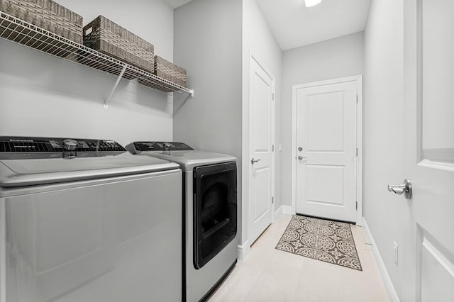 clothes washing area with light tile patterned flooring and washing machine and dryer