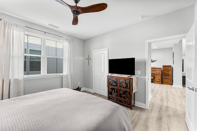 bedroom with light hardwood / wood-style floors, a closet, and ceiling fan