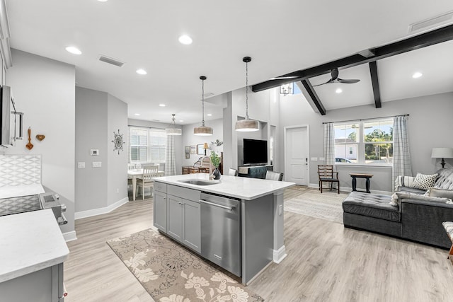 kitchen featuring sink, gray cabinetry, decorative light fixtures, stainless steel dishwasher, and an island with sink