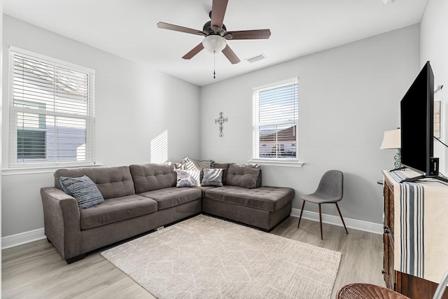 living room with light hardwood / wood-style floors and ceiling fan