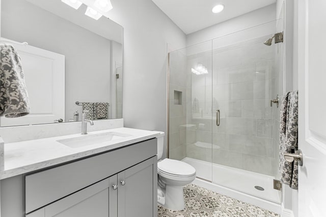 bathroom with walk in shower, vanity, toilet, and tile patterned flooring