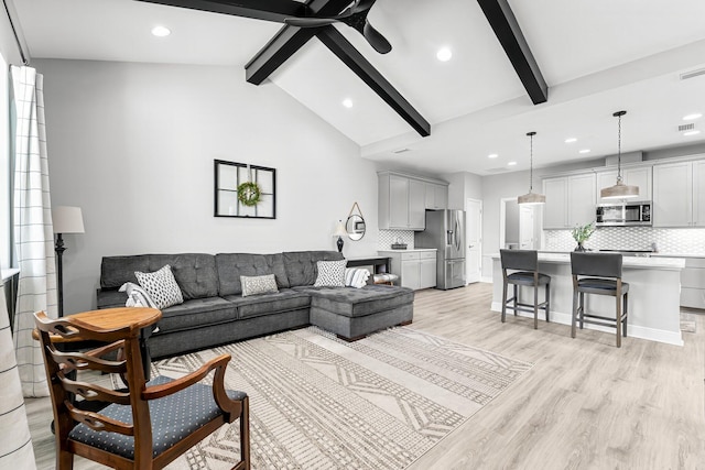 living room featuring ceiling fan, vaulted ceiling with beams, and light hardwood / wood-style floors