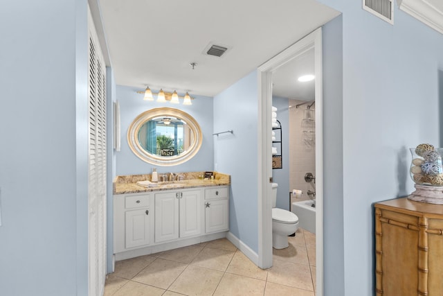 full bathroom featuring vanity, tiled shower / bath, tile patterned floors, and toilet