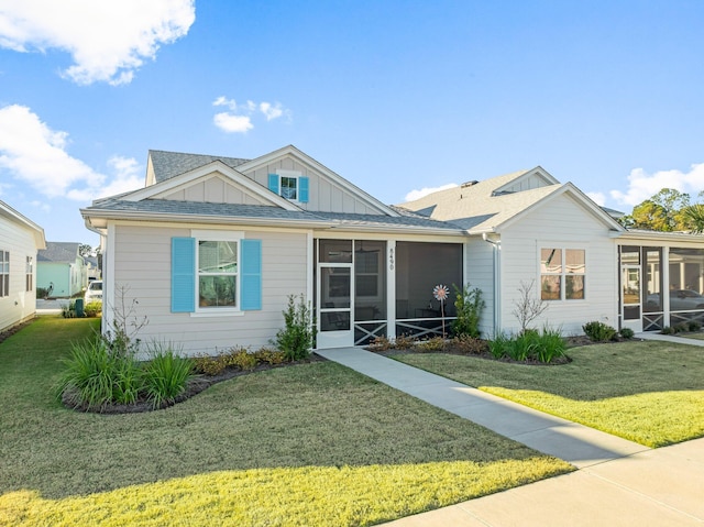 view of front of home with a front lawn and a sunroom