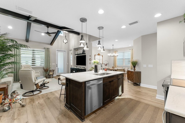 kitchen featuring sink, decorative light fixtures, dark brown cabinets, stainless steel dishwasher, and an island with sink