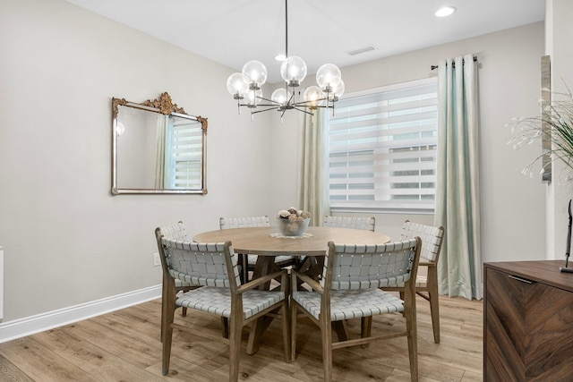 dining space featuring light hardwood / wood-style flooring and a chandelier