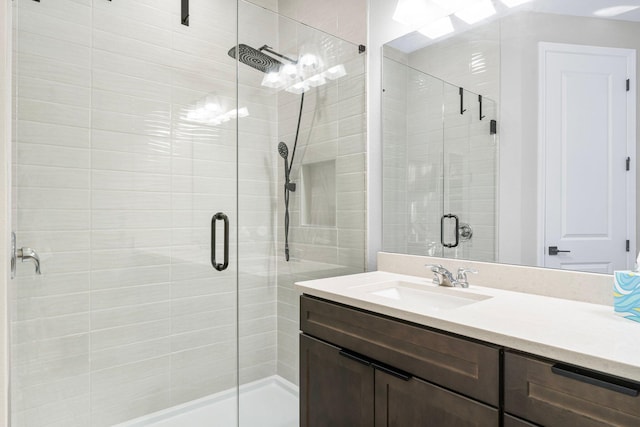 bathroom with vanity and a shower with door