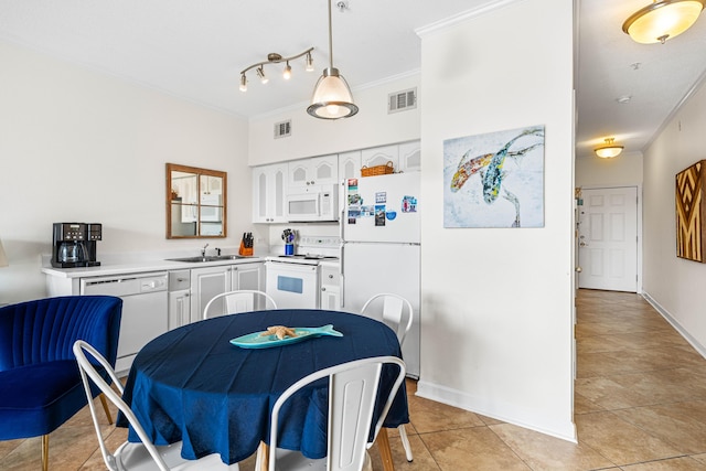 kitchen with sink, white appliances, ornamental molding, white cabinets, and decorative light fixtures