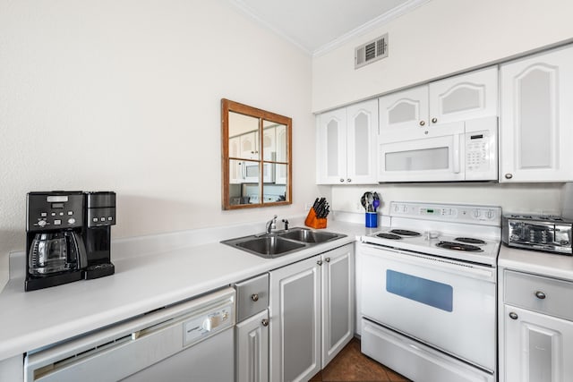 kitchen featuring white cabinetry, sink, dark tile patterned flooring, ornamental molding, and white appliances