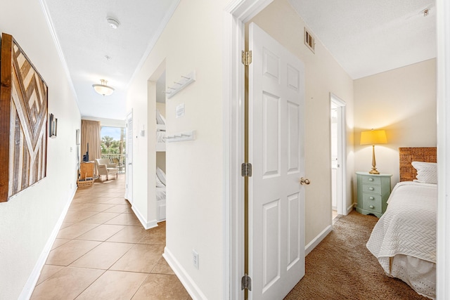 hall with light tile patterned floors and crown molding