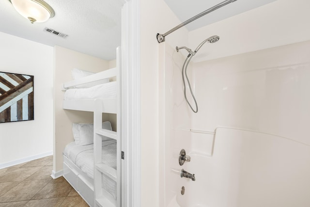 bathroom with shower / tub combination, tile patterned floors, and a textured ceiling