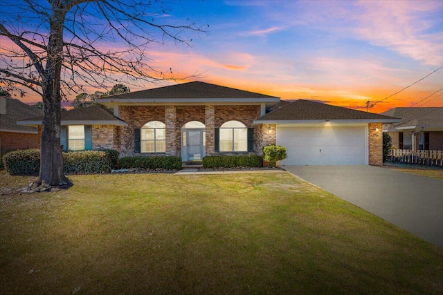 view of front of house with a garage and a lawn