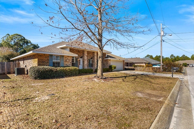 ranch-style home featuring central AC, a garage, and a front yard