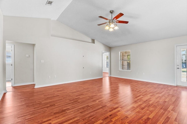 unfurnished living room with ceiling fan, lofted ceiling, a textured ceiling, and light hardwood / wood-style floors