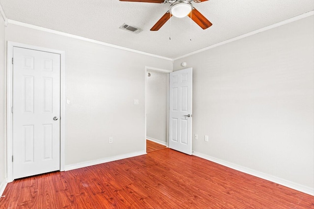 spare room with ornamental molding, hardwood / wood-style floors, ceiling fan, and a textured ceiling