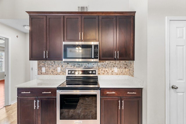 kitchen featuring tasteful backsplash, dark brown cabinets, and stainless steel appliances