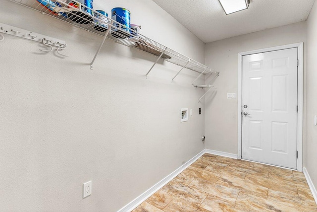 clothes washing area with washer hookup, a textured ceiling, and electric dryer hookup