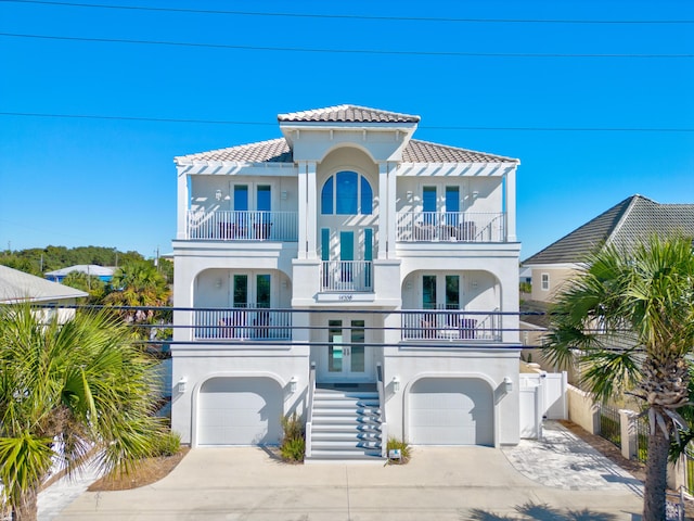 view of front facade featuring french doors, a balcony, and a garage