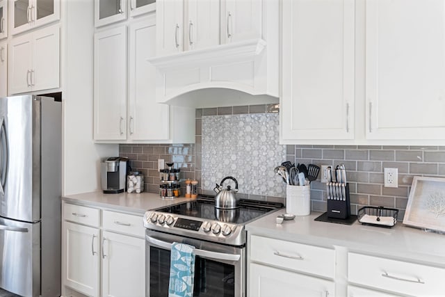 kitchen with white cabinetry, backsplash, and appliances with stainless steel finishes