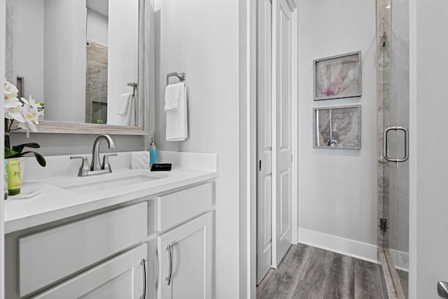 bathroom featuring vanity, wood-type flooring, and a shower with door