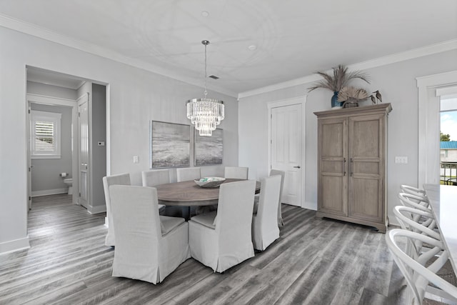 dining room featuring a notable chandelier, hardwood / wood-style flooring, and ornamental molding